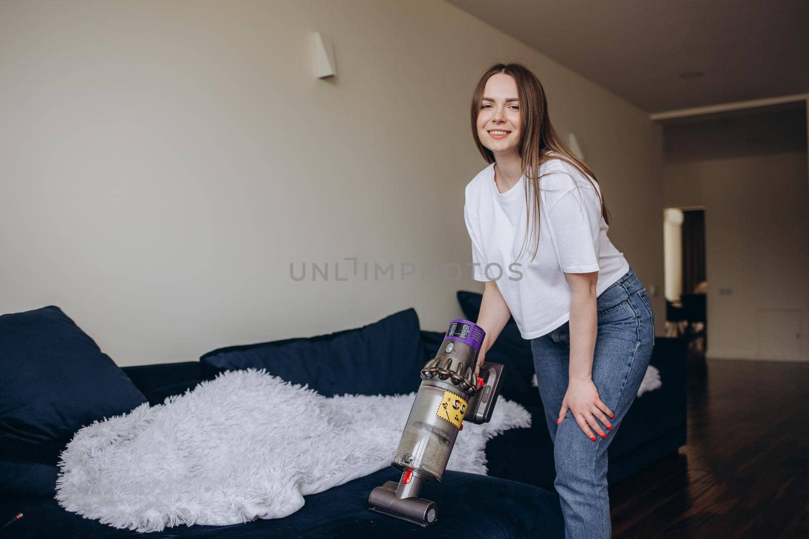 Attractive girl with vacuum cleaner on light background.