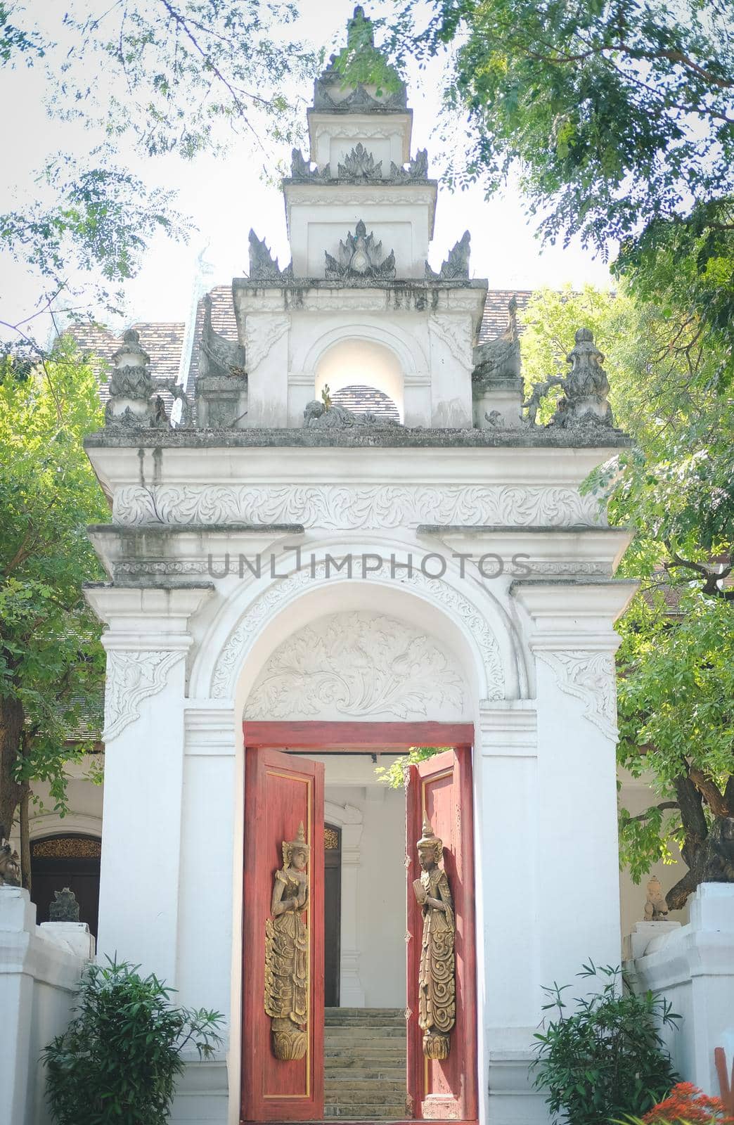 old vintage wooden door arch with asian angel sculpture