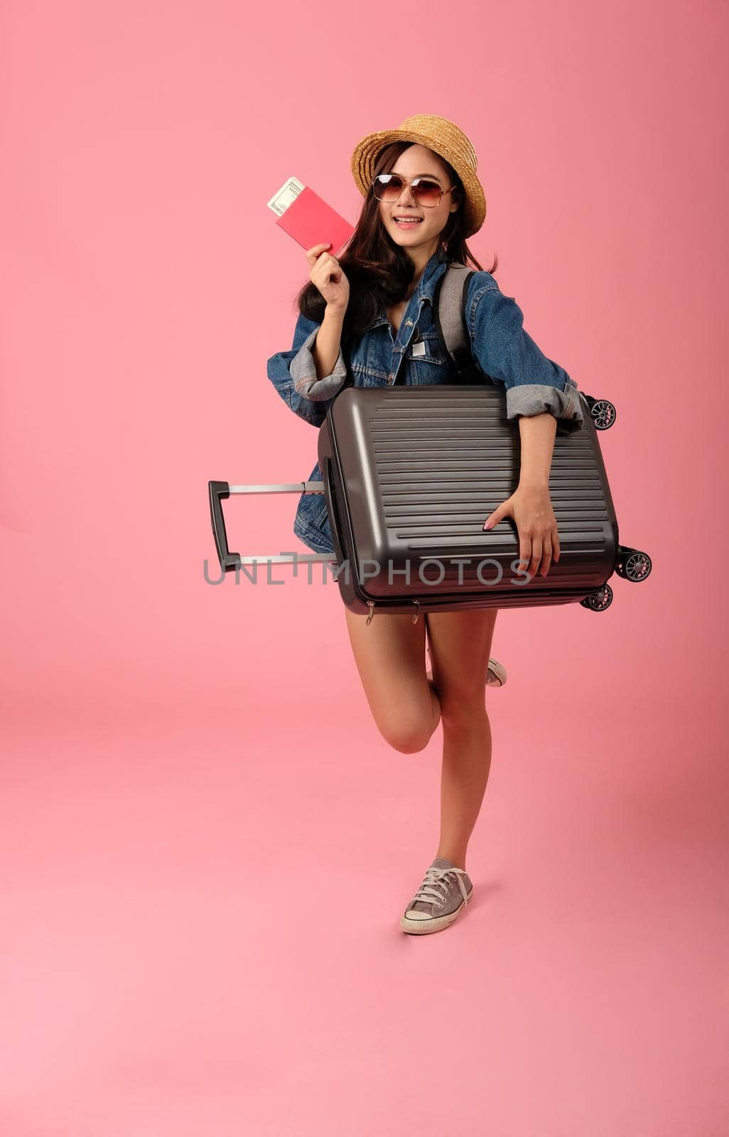 young asian woman backpacker traveler with passport money luggage. journey trip travel. studio shot