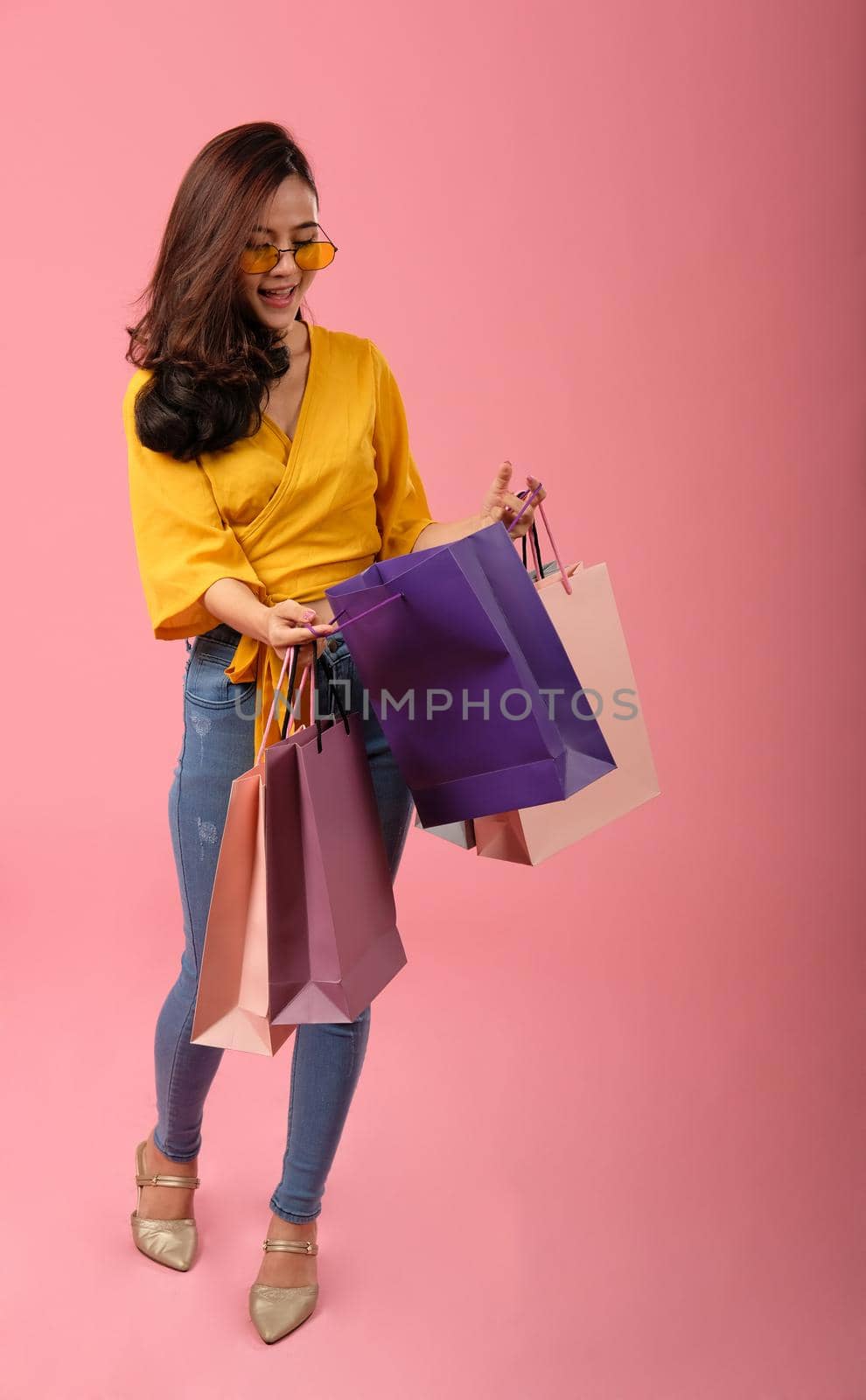 woman holding shopping bags. consumerism shopaholic lifestyle studio shot