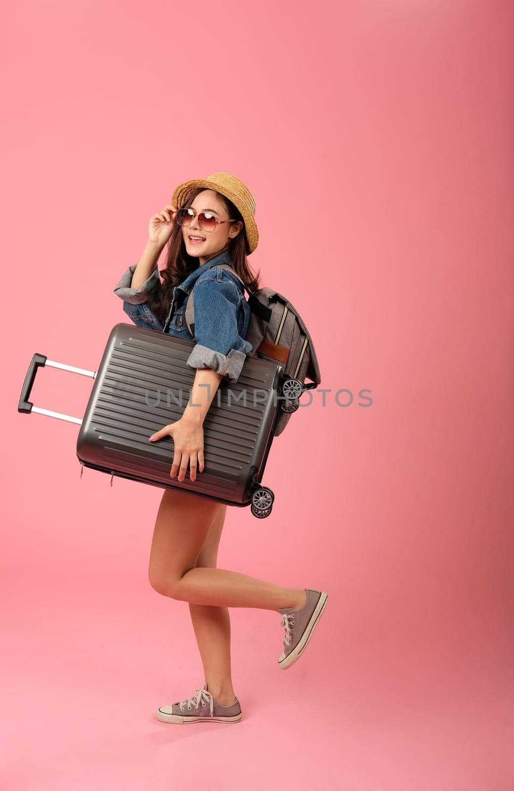 young asian woman backpacker traveler with baggage. journey trip travel. studio shot