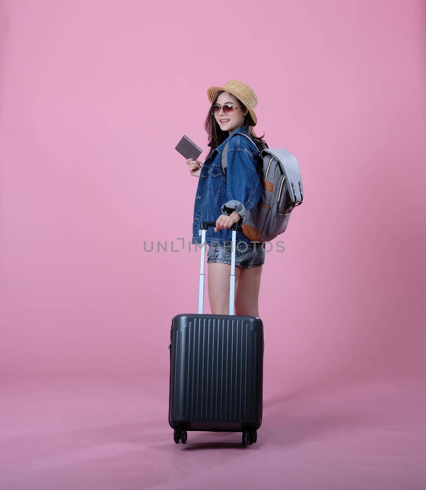 young asian woman backpacker traveler with backpack & passport. . journey trip travel. studio shot