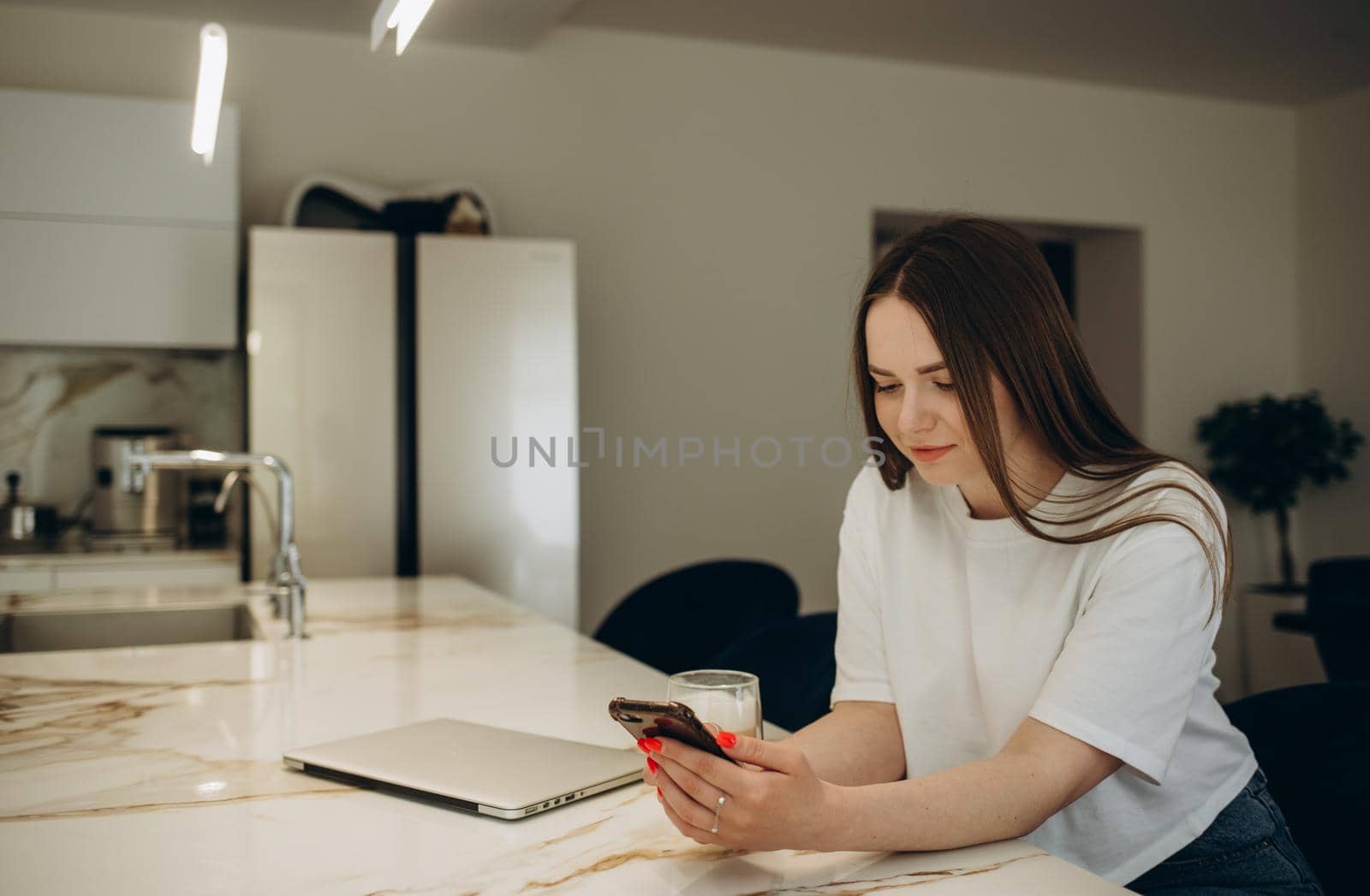 Cute smiling woman reading or searching recipe. Student girl using smartphone at home. Connection, communication, online shopping, distance learning, studying, lockdown concept by fentonroma