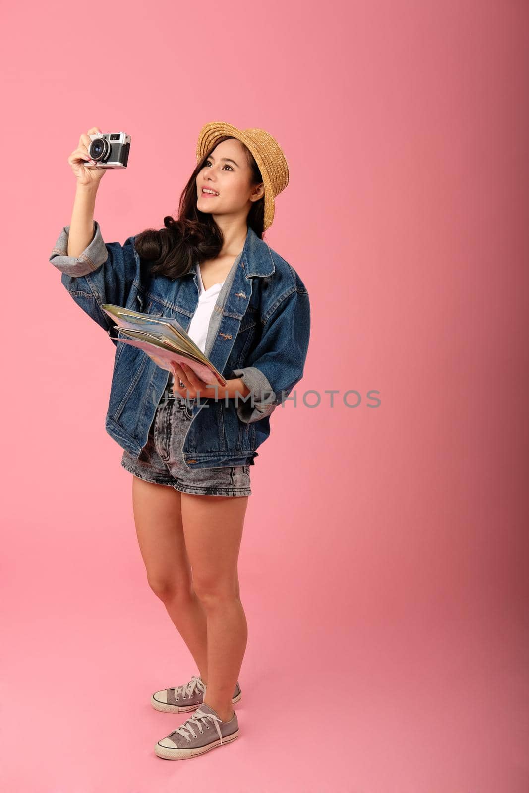 young asian woman backpacker traveler with camera map. journey trip travel. studio shot