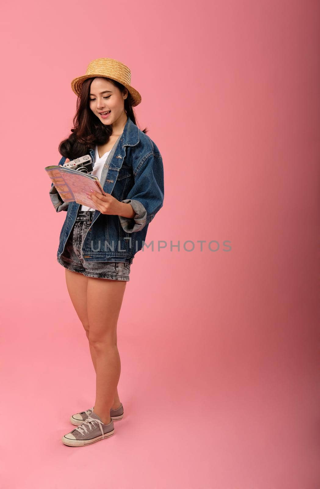 young asian woman backpacker traveler with camera map. journey trip travel. studio shot