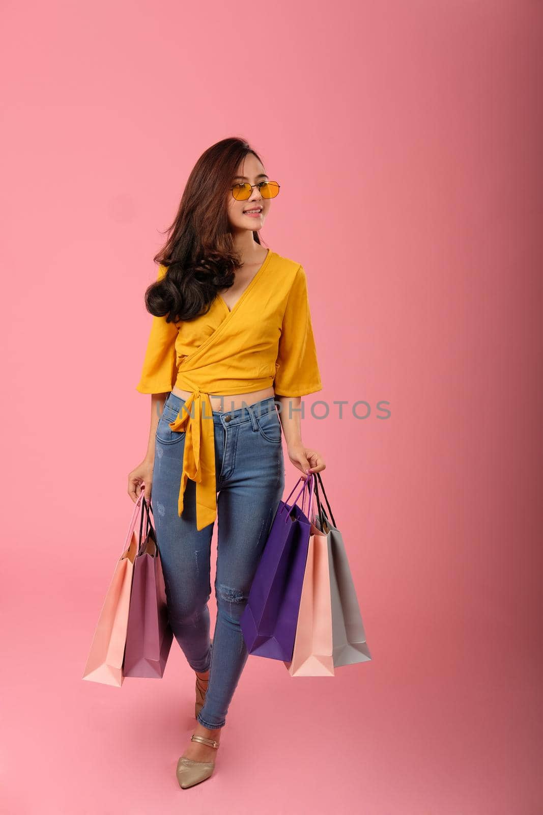 woman holding shopping bags. consumerism shopaholic lifestyle studio shot