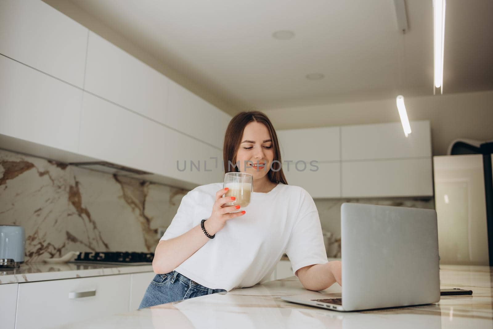 Happy woman using laptop in cook room by fentonroma