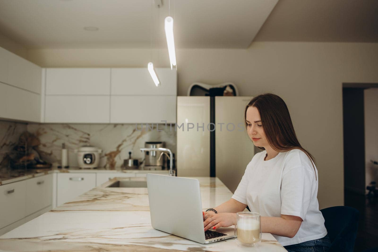 Happy woman using laptop in cook room.