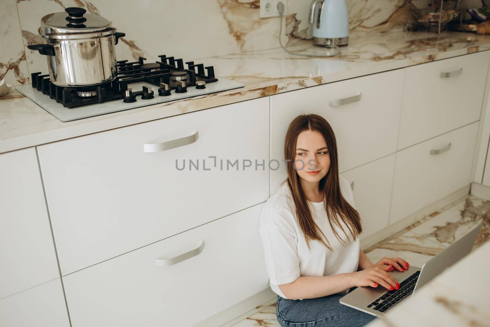 Happy woman using laptop in cook room.