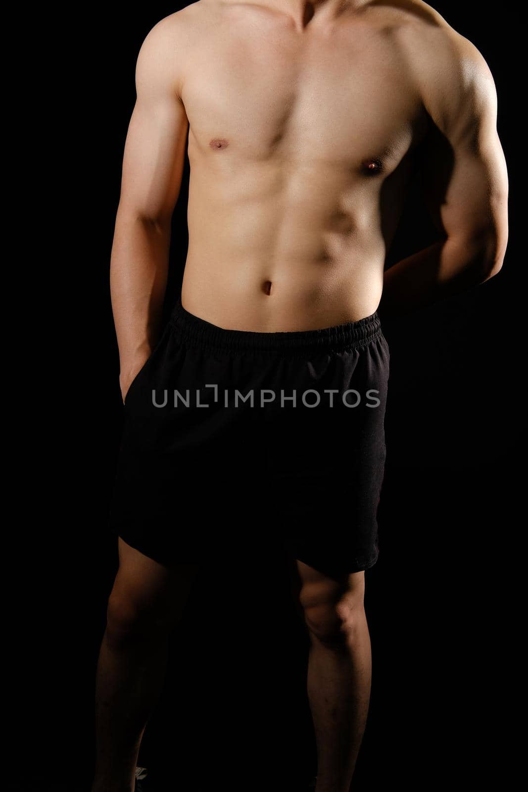 portrait of athletic muscular bodybuilder man with naked torso six pack abs. fitness workout concept