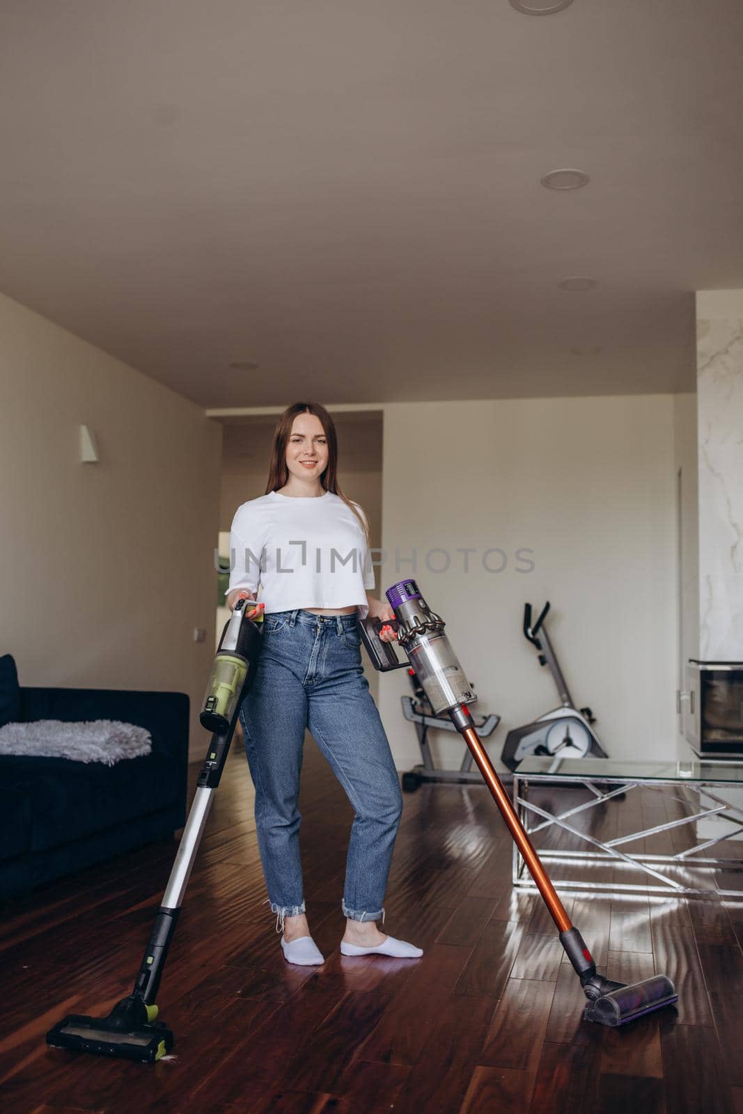 Young woman with rechargeable vacuum cleaner cleaning at home.