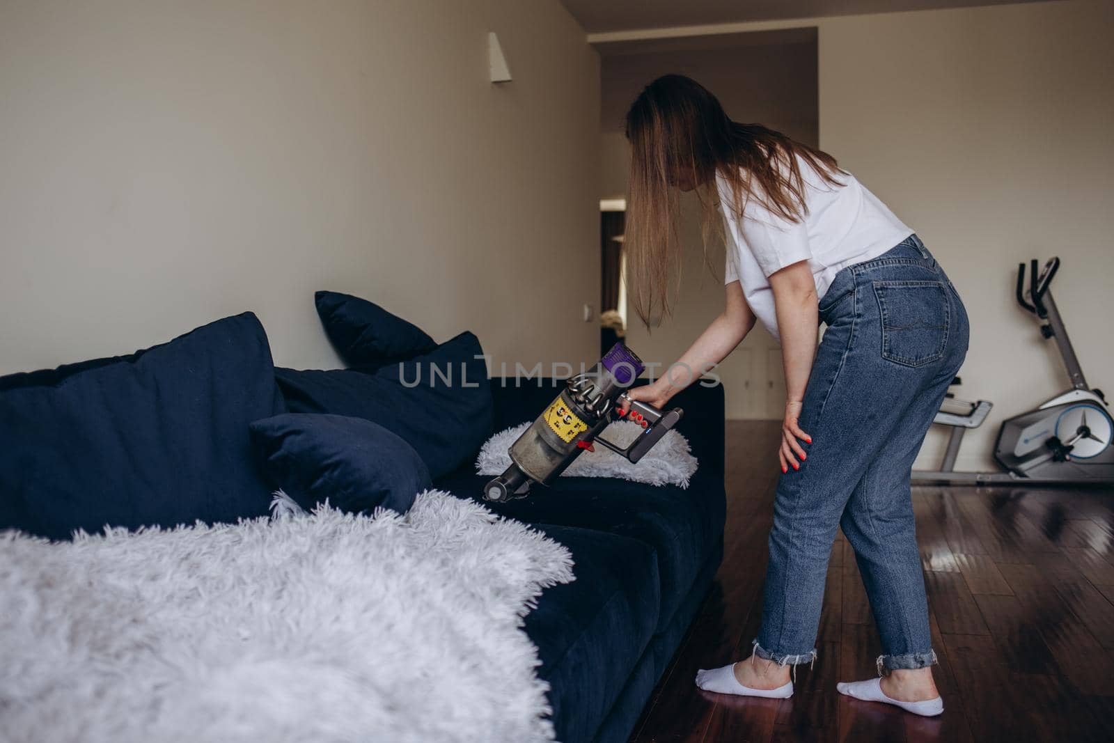 girl cleaning the sofa with a vacuum cleaner by fentonroma