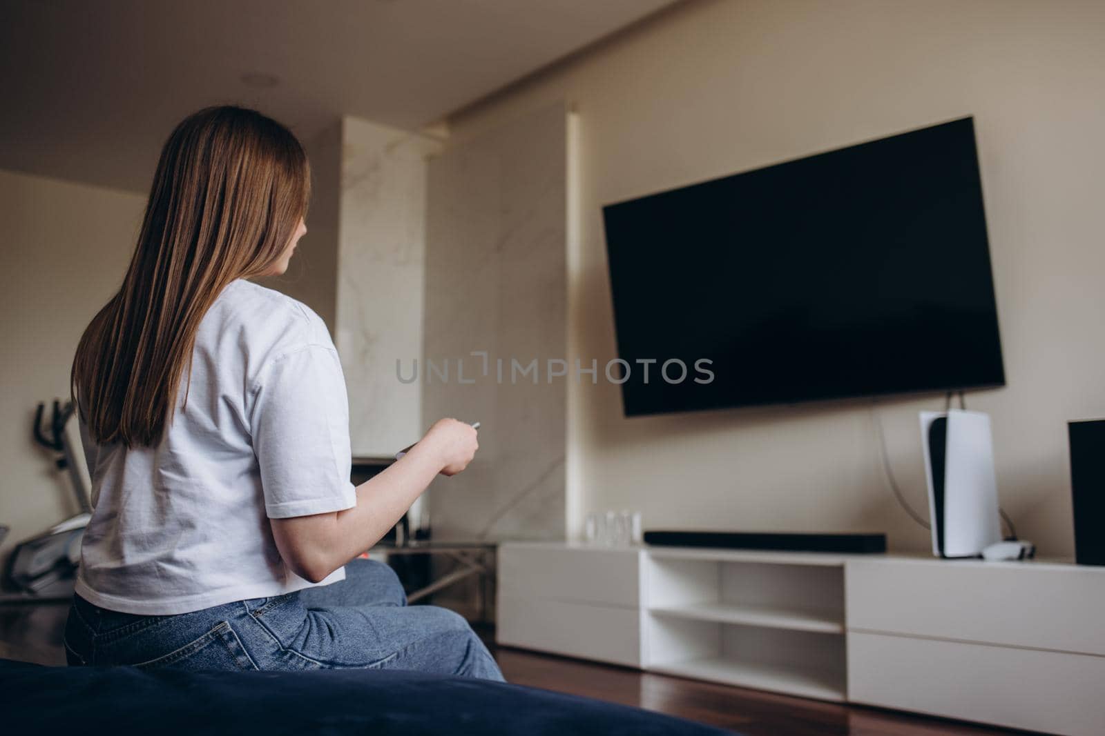 Young woman watching TV in the room.