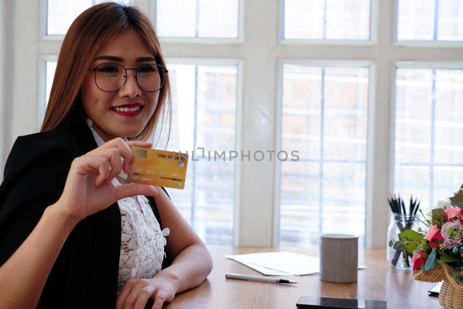 smiling asian woman with credit card for shopping online.