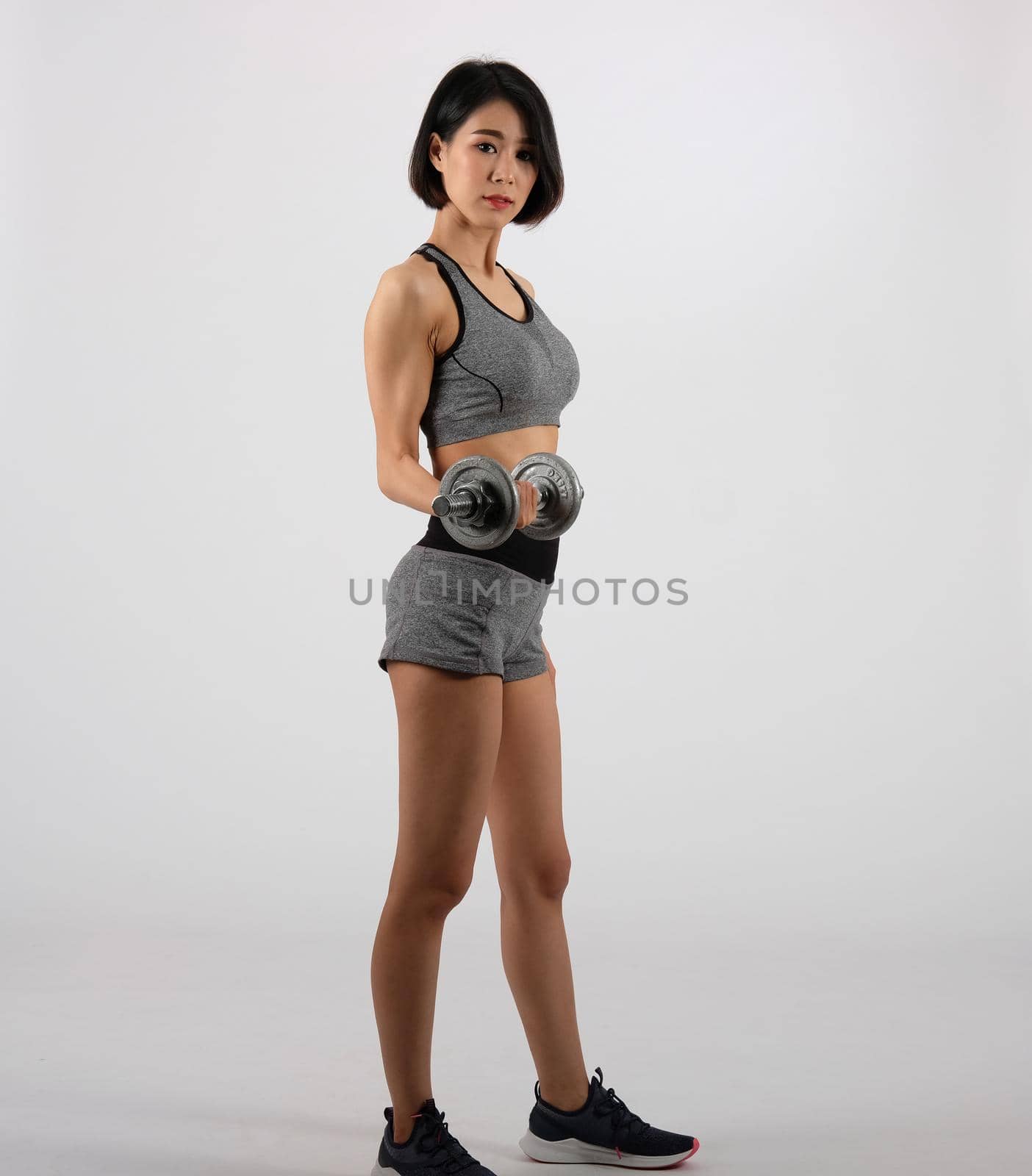 asian sporty woman in sportswear with dumbbell doing fitness workout on white background. healthy sport lifestyle