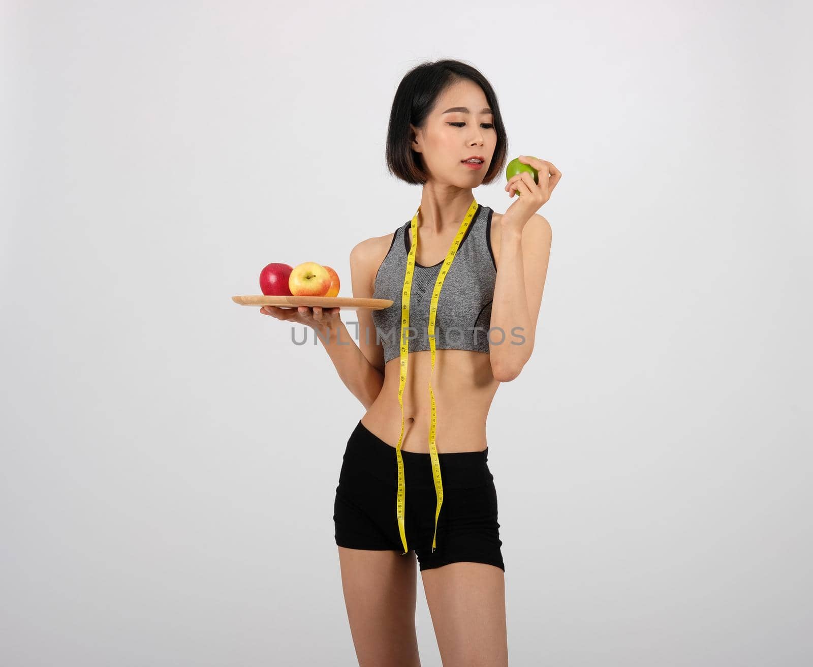 sporty fitness woman in sportswear with apple on white background. healthy sport lifestyle