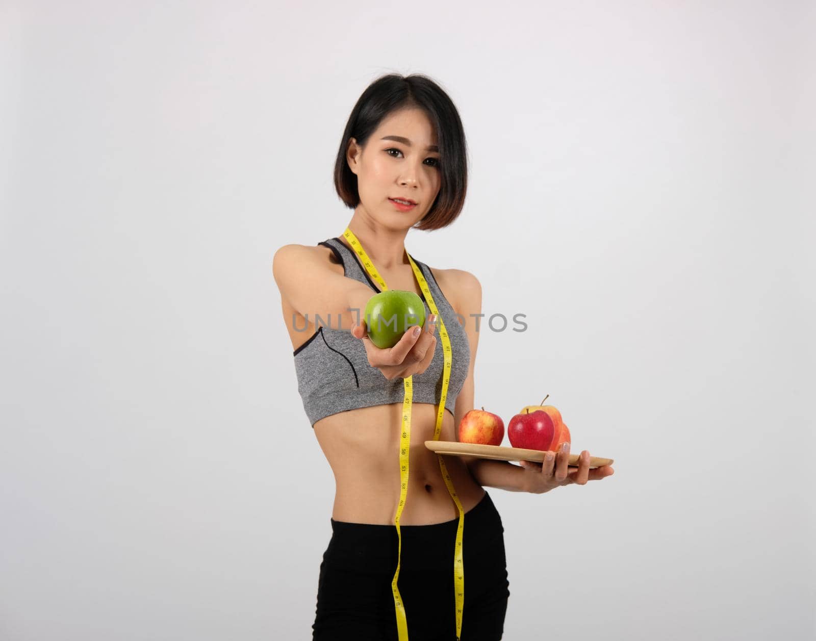 sporty fitness woman in sportswear with apple on white background. healthy sport lifestyle