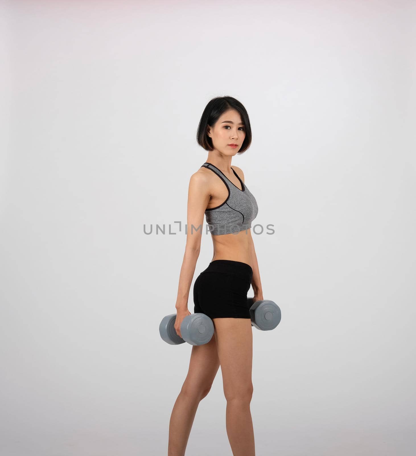 sporty woman in sportswear with dumbbell doing fitness workout on white background. healthy sport lifestyle by pp99