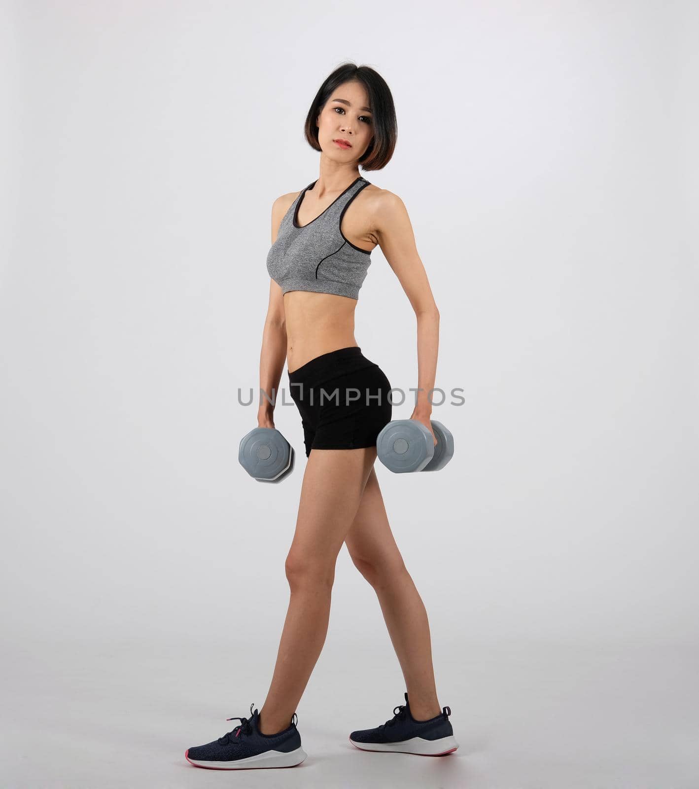 asian sporty woman in sportswear with dumbbell doing fitness workout on white background. healthy sport lifestyle