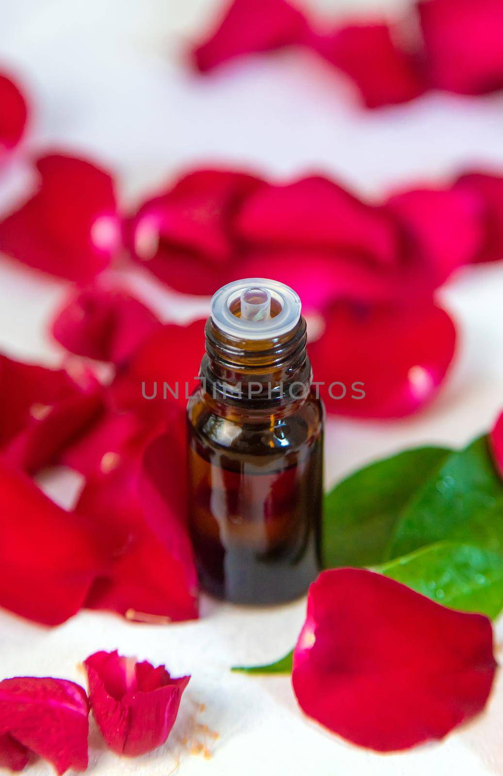Rose essential oil in a small bottle. Selective focus. by yanadjana
