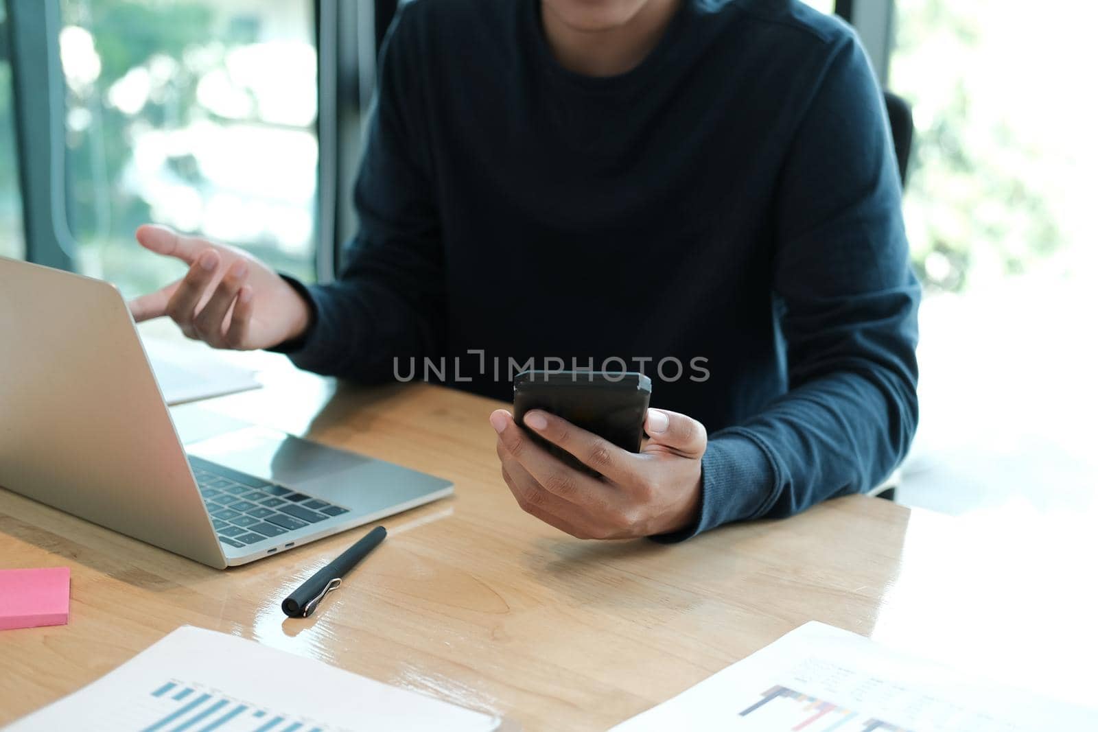 startup man using smart mobile phone. male freelancer working with computer at workplace