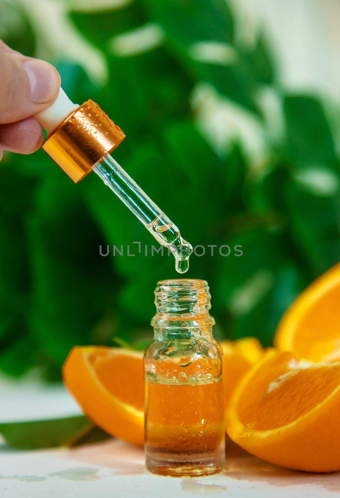 Orange essential oil in a small bottle. Selective focus. Nature.