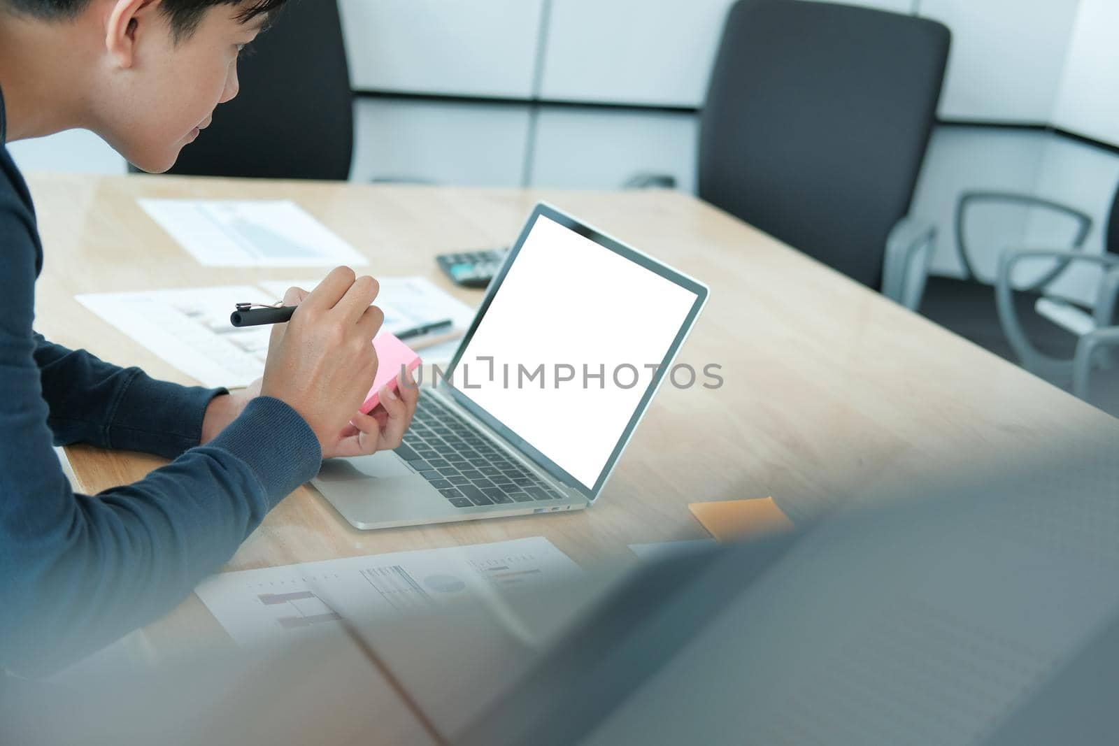 startup man writing reminder on sticky note. male freelancer student working organizing plan at workplace