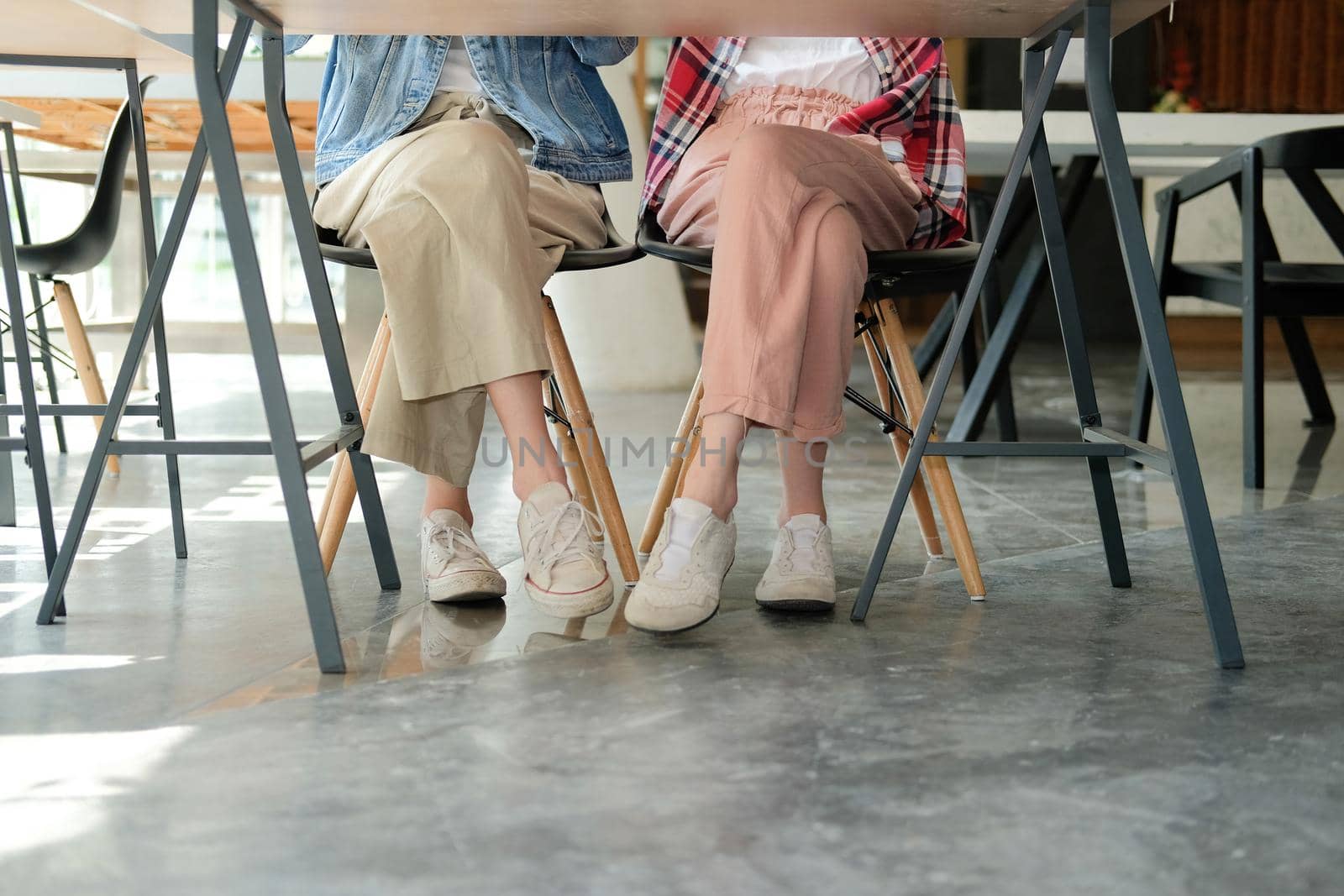 girl teenager friends legs wearing white sneakers sitting talking together. friendship leisure lifestyle