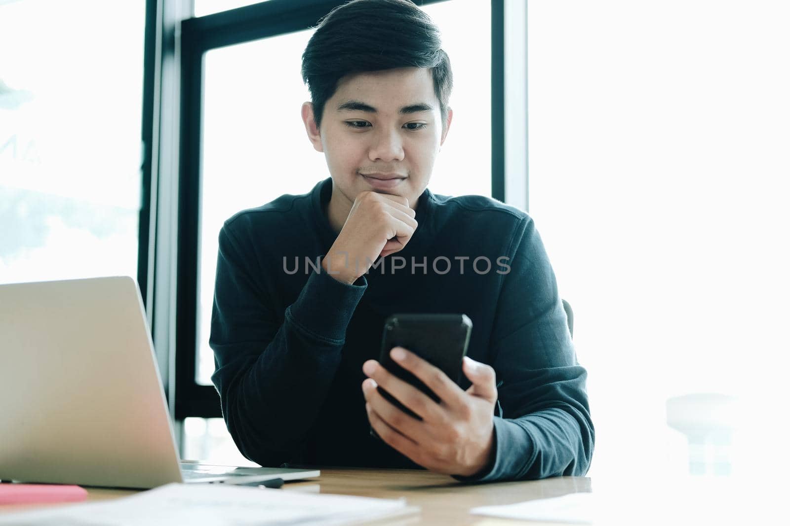 male freelancer using mobile smart phone. startup man entrepreneur working at workplace.