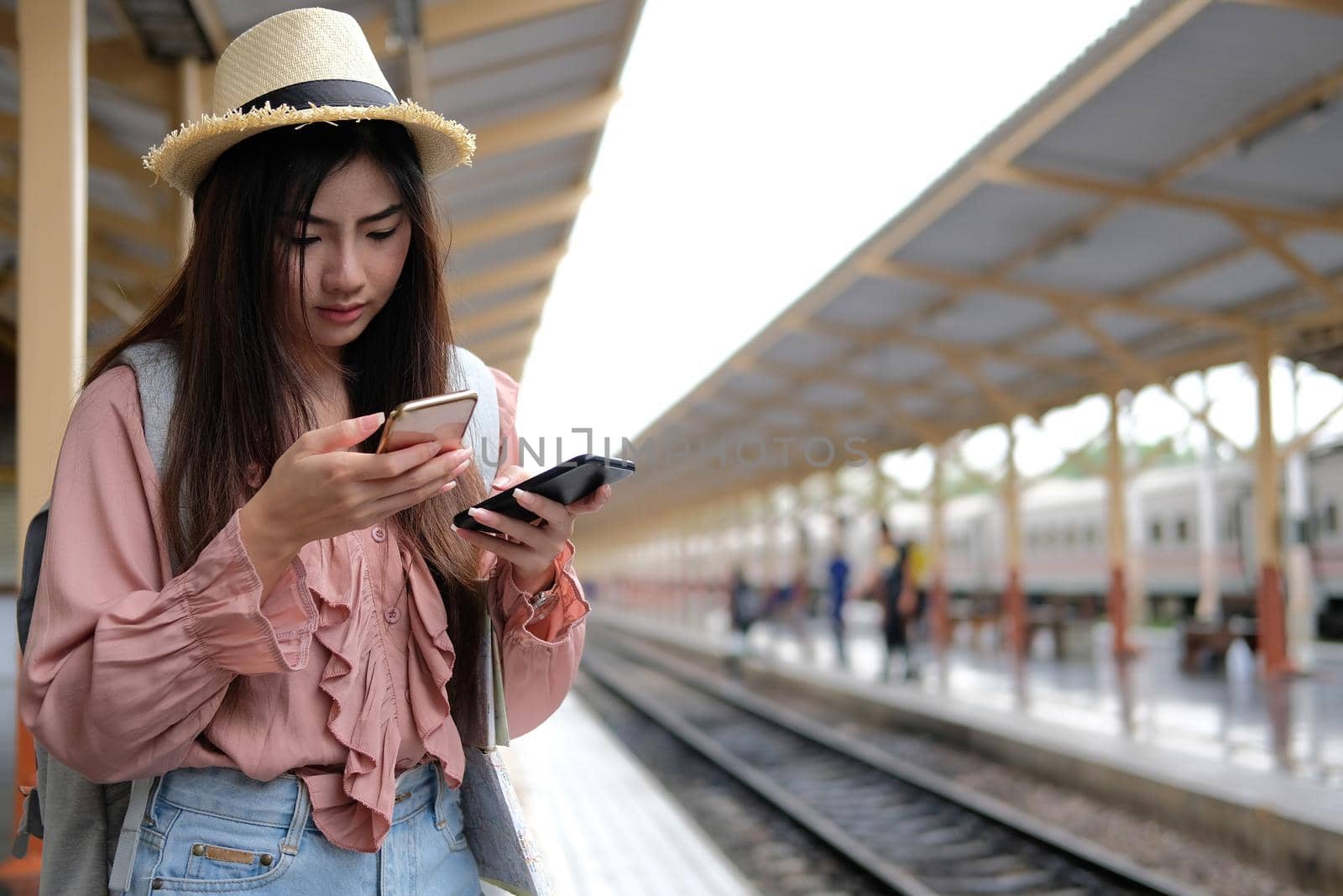 young woman traveler using mobile smart phone at train station. Travel journey trip concept