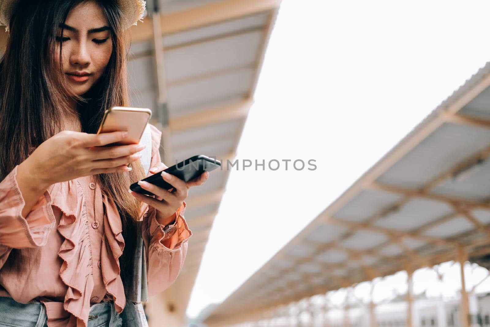 young woman traveler using mobile smart phone at train station. Travel journey trip concept