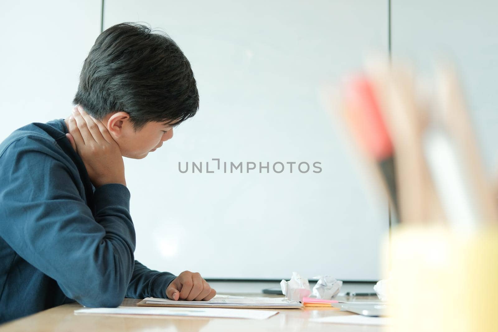 man feeling tired, frustrated & stressed from hard work with crumpled crushed paper on desk. exhausted freelancer have headache at workplace.