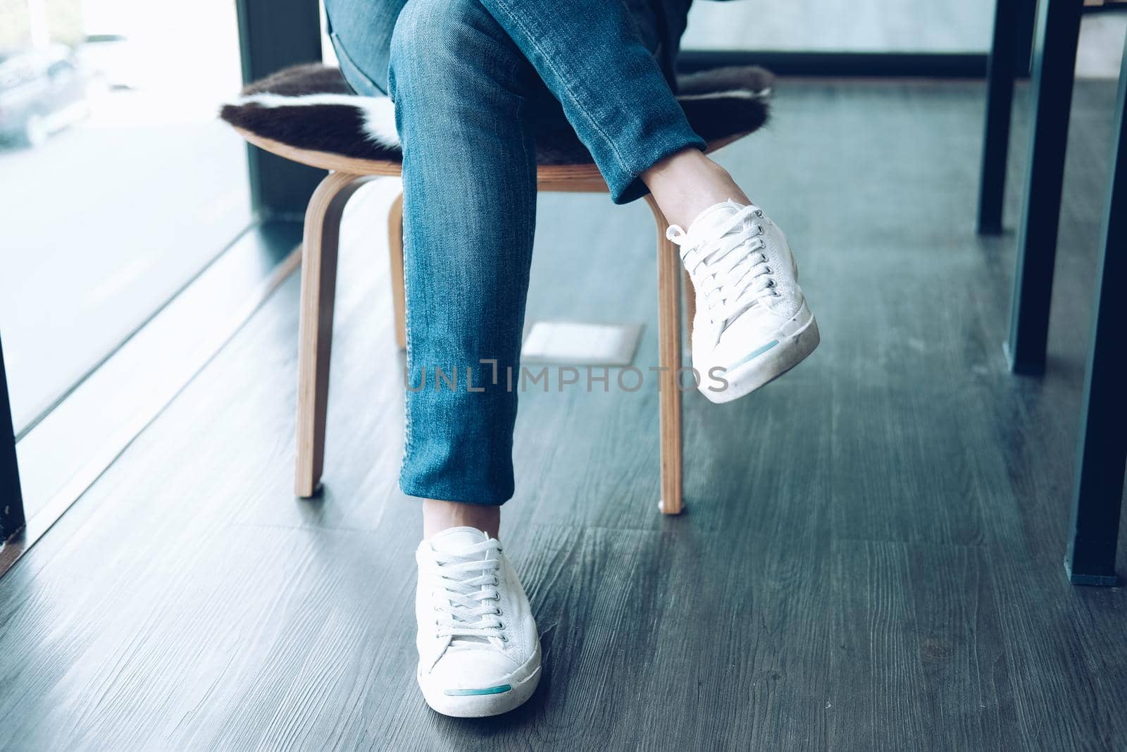 man teenager legs wearing white sneakers sitting relaxing at home. teenage male leisure lifestyle