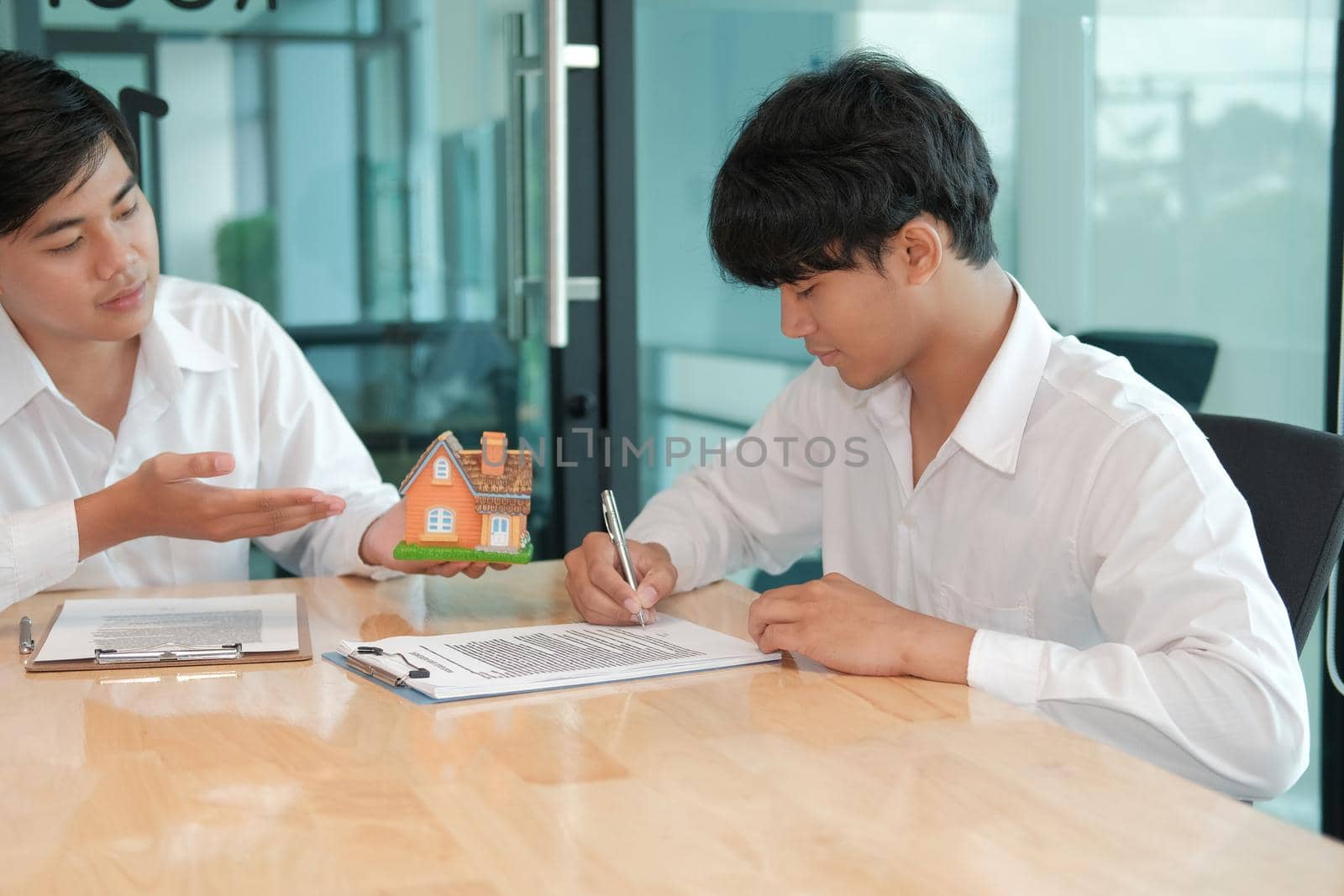 man signing contract agreement with realtor. buying, selling buying renting real estate property