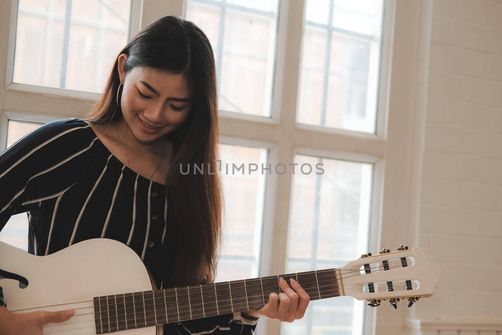 woman playing guitar at home.  leisure lifestyle concept