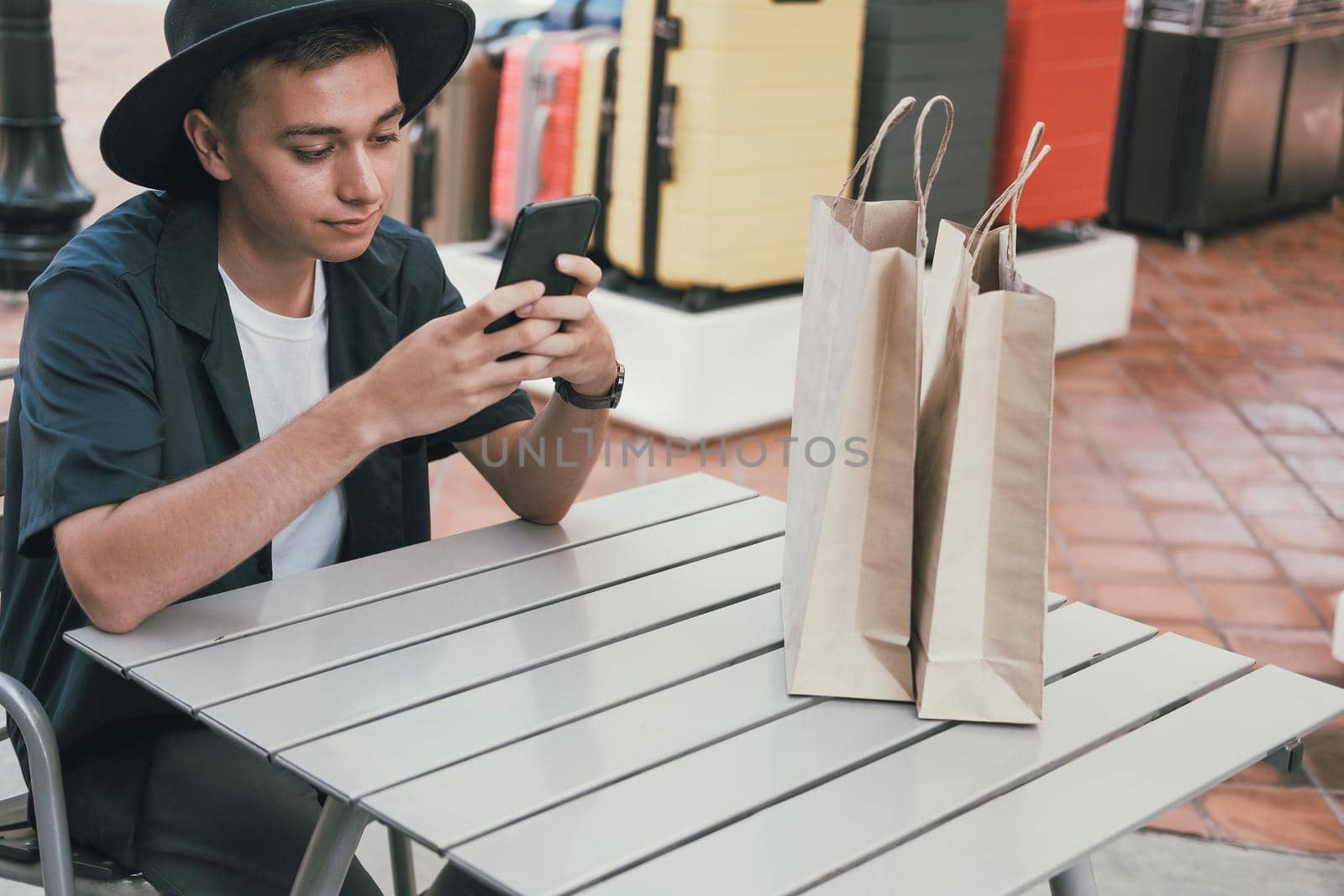 man using mobile smart phone with paper shopping bags. consumerism lifestyle