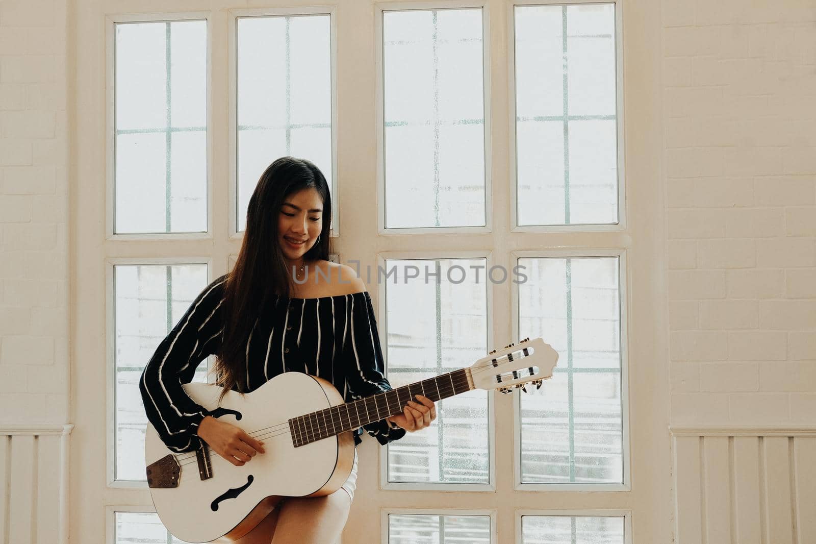 woman playing guitar at home.  leisure lifestyle concept