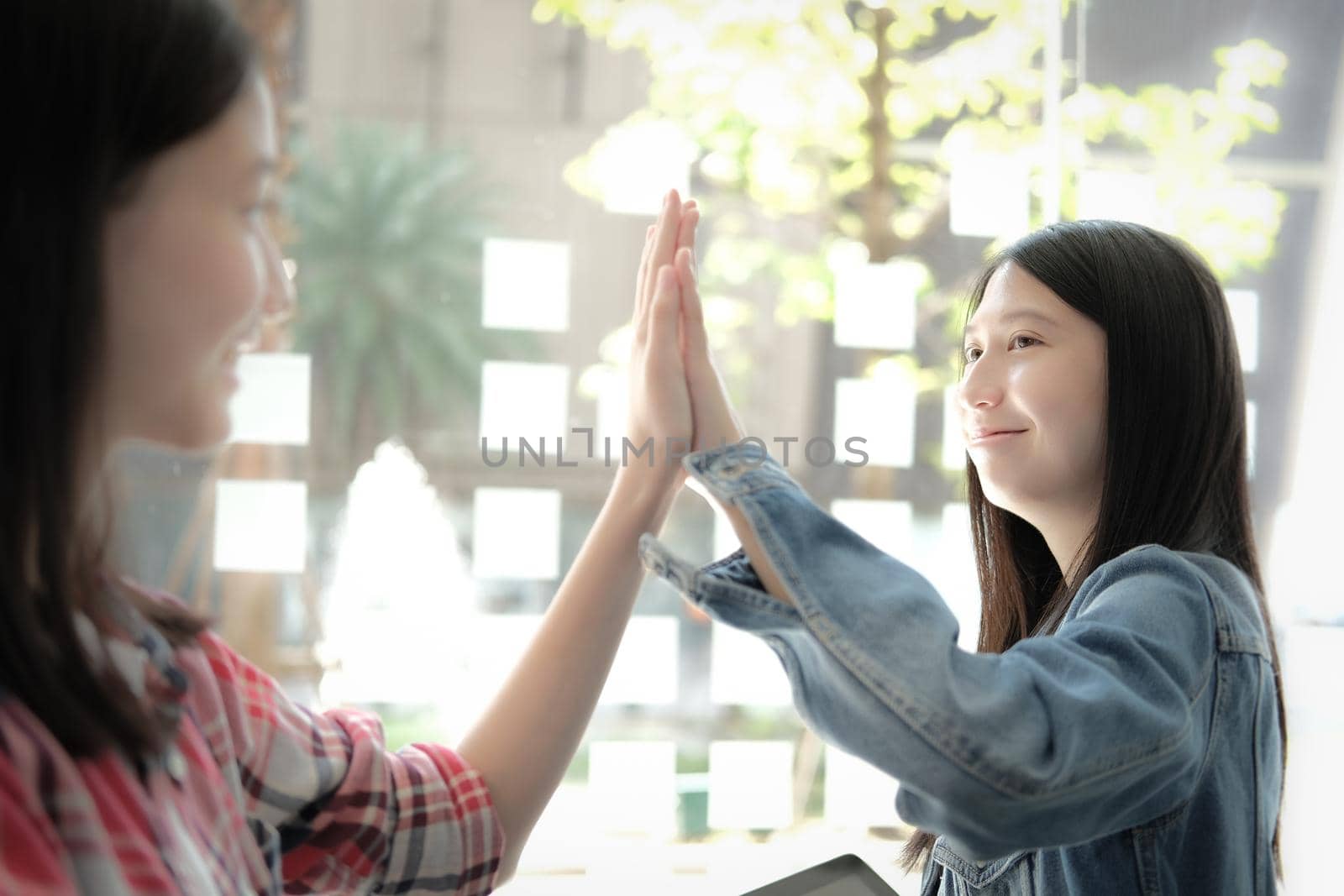 girl teenager giving high five touching hands together. teamwork friendship  by pp99