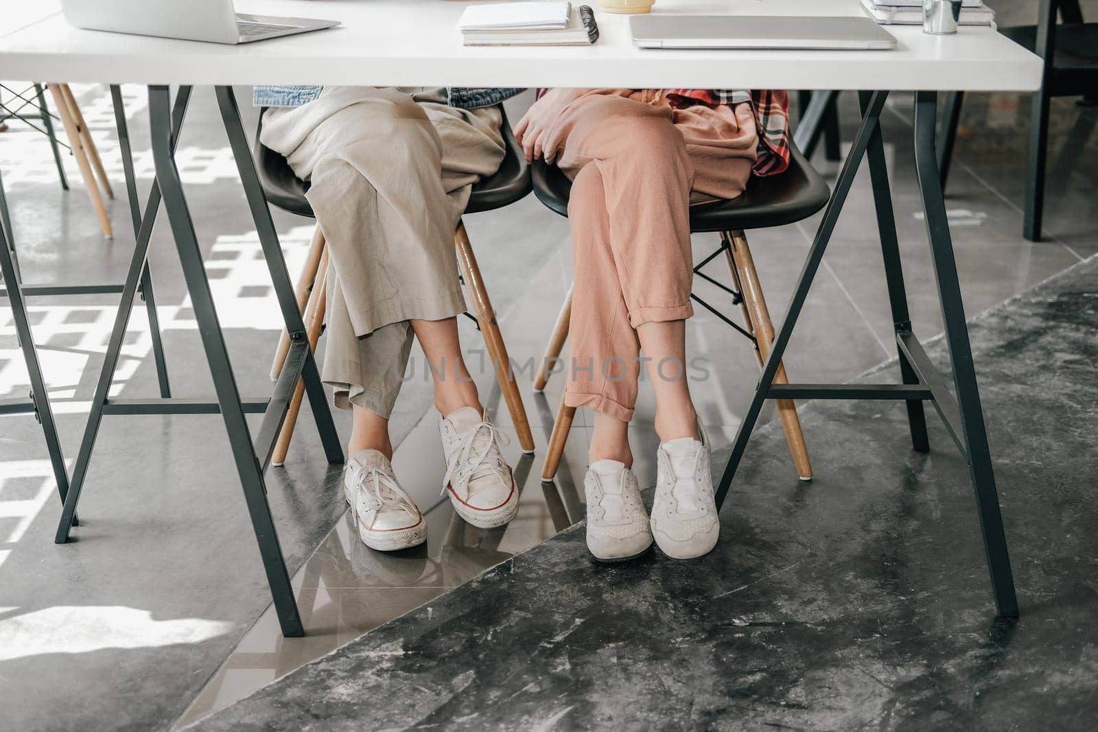 girl teenager friends legs wearing white sneakers sitting talking together. friendship leisure lifestyle