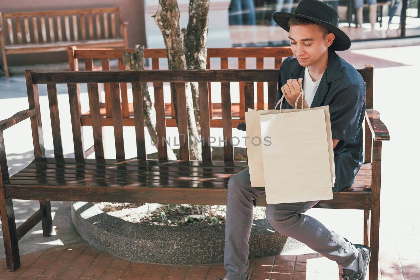 man sitting resting with shopping bags at shopping mall. consumerism lifestyle