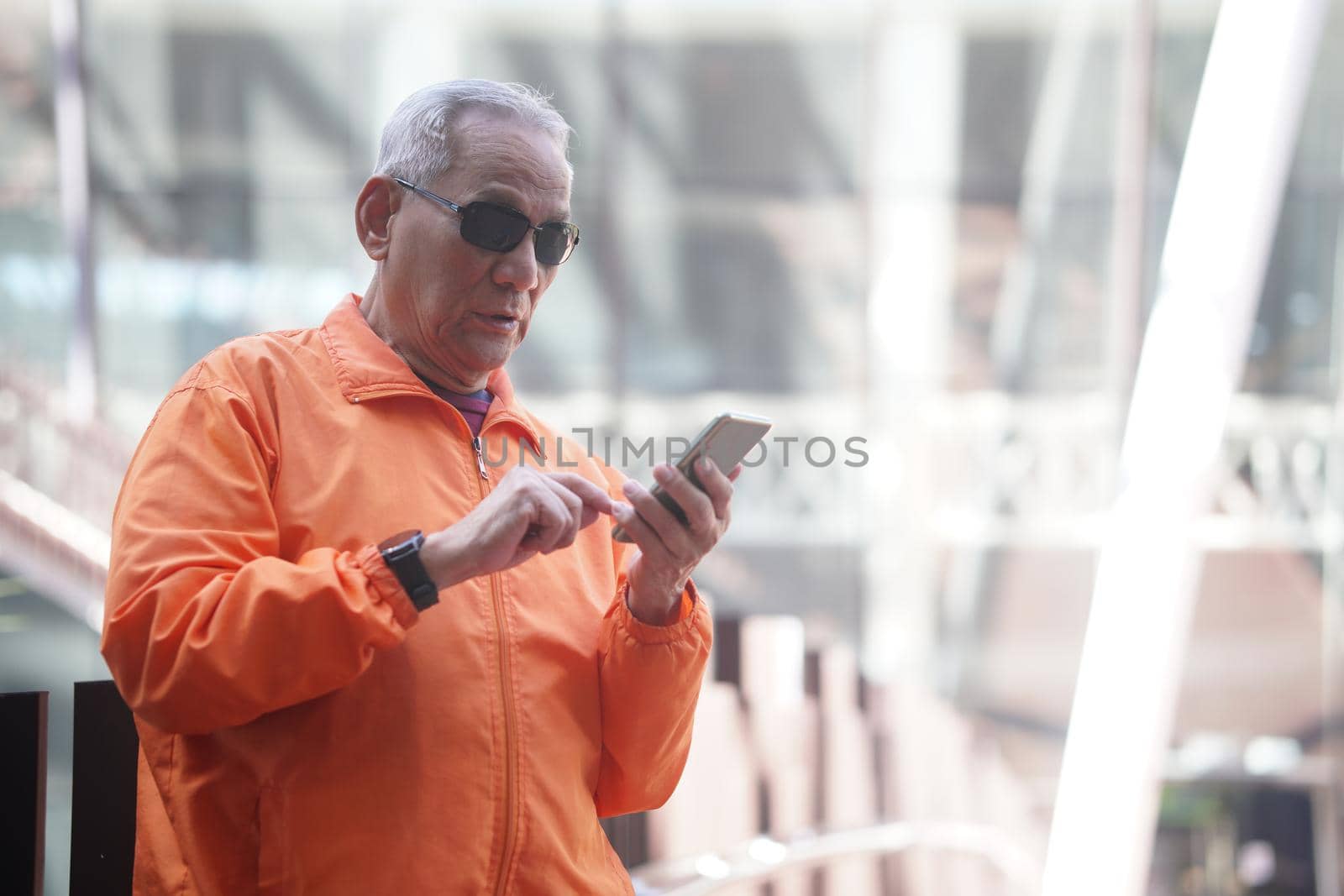 asian old elder senior man elderly using mobile smart phone cellphone outdoor. mature retirement lifestyle