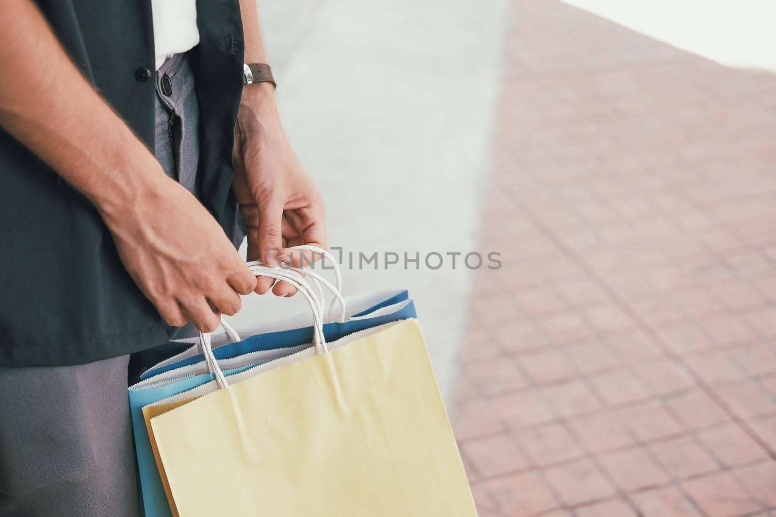 man with shopping bags at shopping mall. consumerism lifestyle