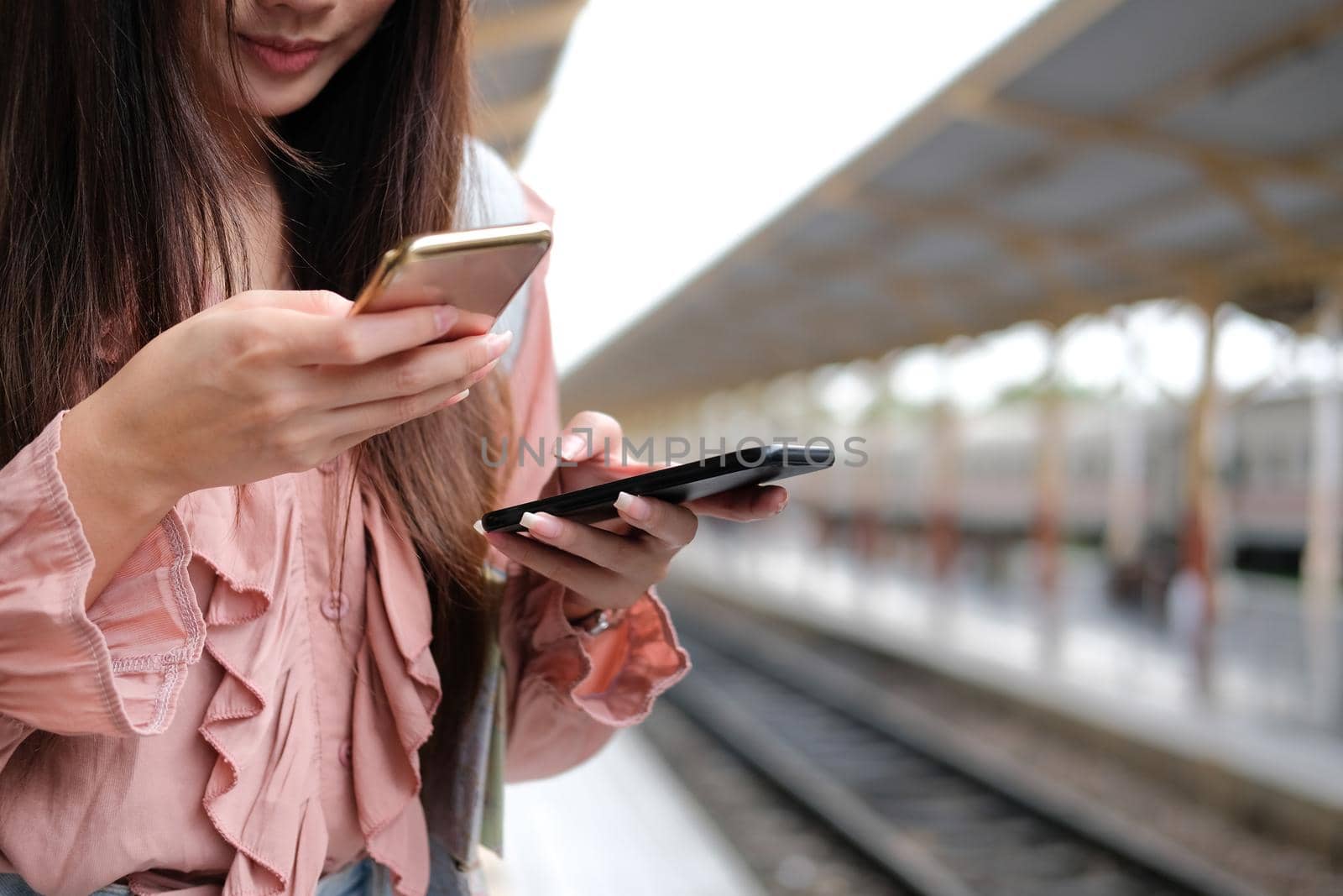 young woman traveler using mobile smart phone at train station. Travel journey trip concept