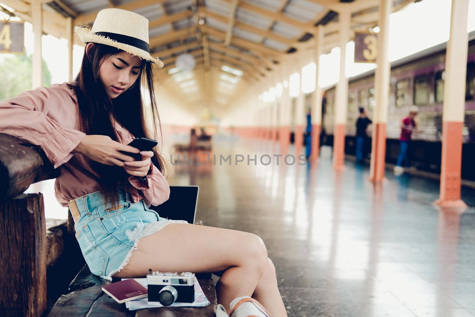 young woman traveler using mobile smart phone at train station. Travel journey trip concept