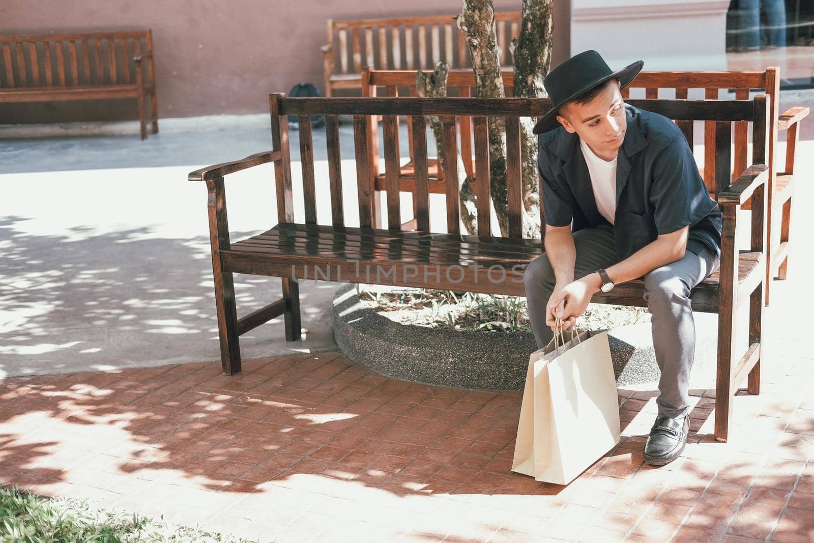 man sitting resting with shopping bags at shopping mall. consumerism lifestyle