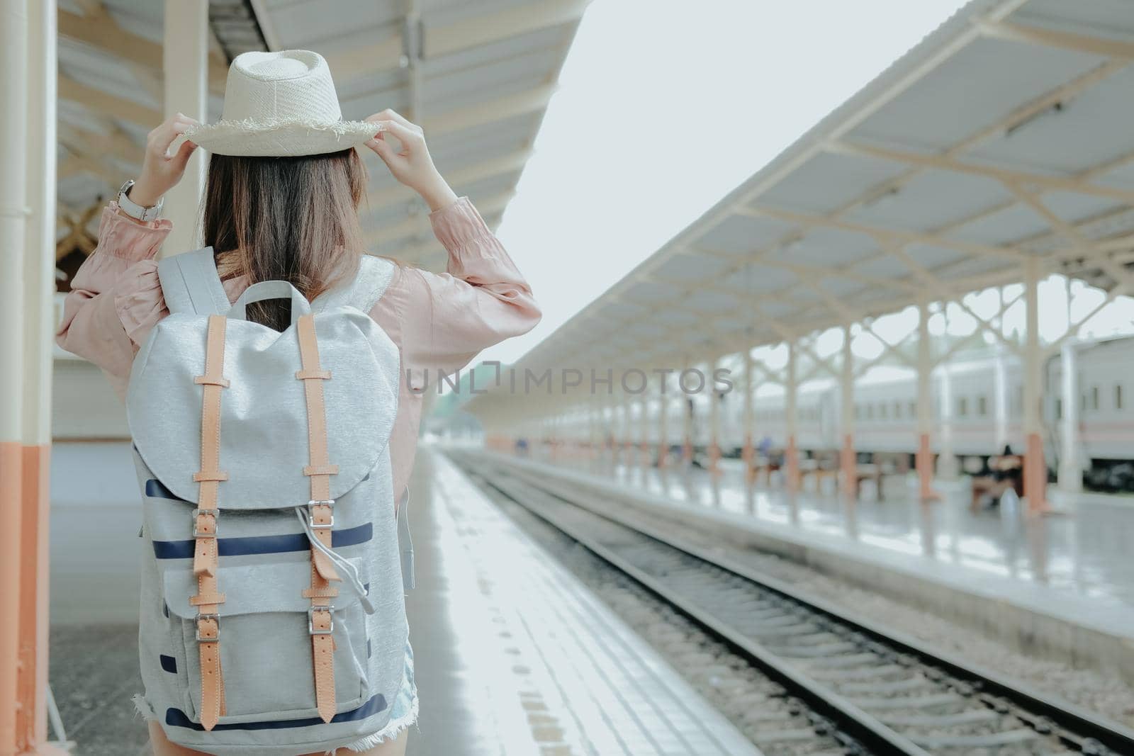 young asian woman  backpacker traveler with backpack at train station. journey trip travel concept