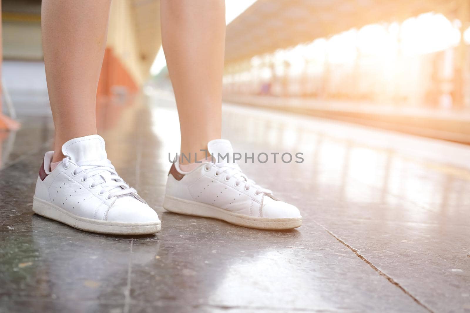 young woman traveler with white sneakers at train station. journey trip travel concept