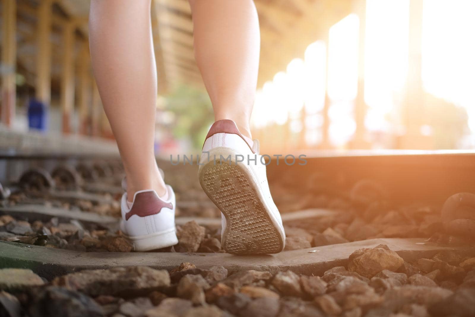 young woman traveler with white sneakers at train station. journey trip travel concept