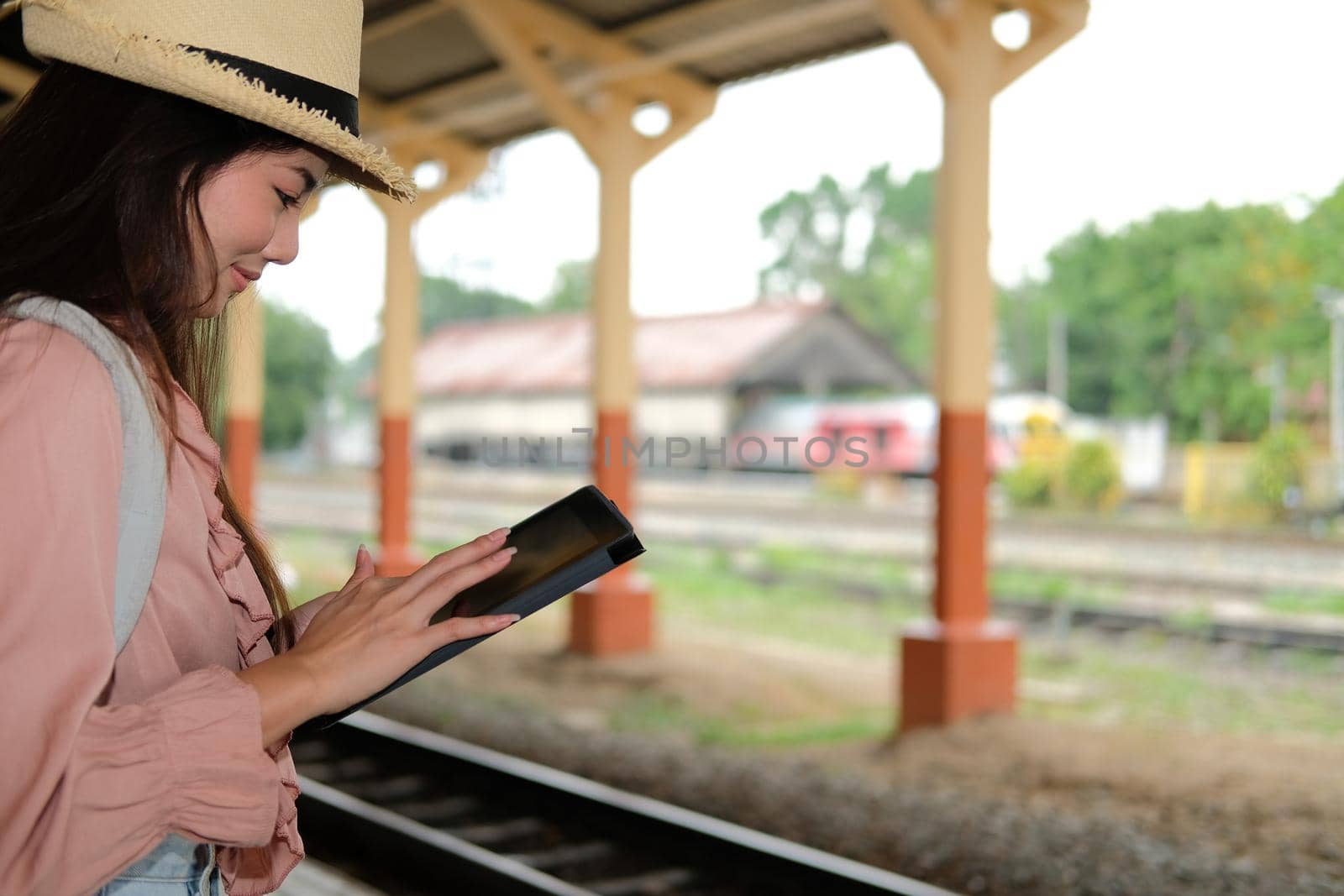 woman traveler using tablet at train station. Travel journey trip concept by pp99