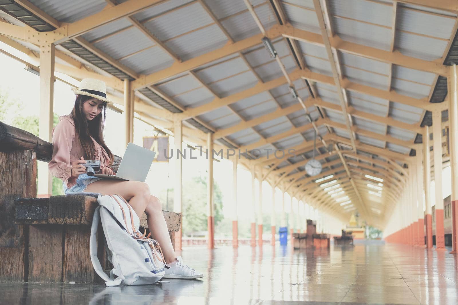 young woman traveler using computer at train station. Travel journey trip concept